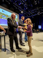 Studentin Lene bekommt ihr KinderUni-Diplom aus den Händen von Rektor Ludwig Hilmer und Prof. Detlev Müller, der in diesem Jahr auch schon einmal KinderUni-Dozent war.