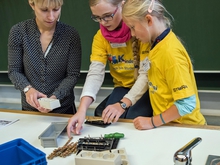 Katharina Müller-Eppendorfer schaut zu, wie Lilly-Ann und Amelie (v.l.) unter schlechten Bedingungen die Steckdose zusammenzubauen. 