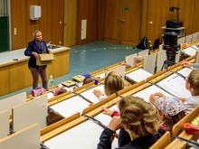 Prof. Isolde Heintze hält den Staatshaushalt (eine Kiste Schokomünzen) in den Händen