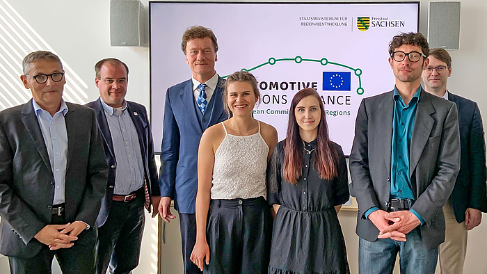 Sächsisches Staatsministerium für Regionalentwicklung Dresden (SMR): das Sieger-Logo für die Automotive Regions Alliance, entworfen von Vanessa Meyer (5.v.l.), hier mit Kommiliton:innen, ihrem Dozenten und Mitarbeitenden des Ministeriums. (Foto:SMR)