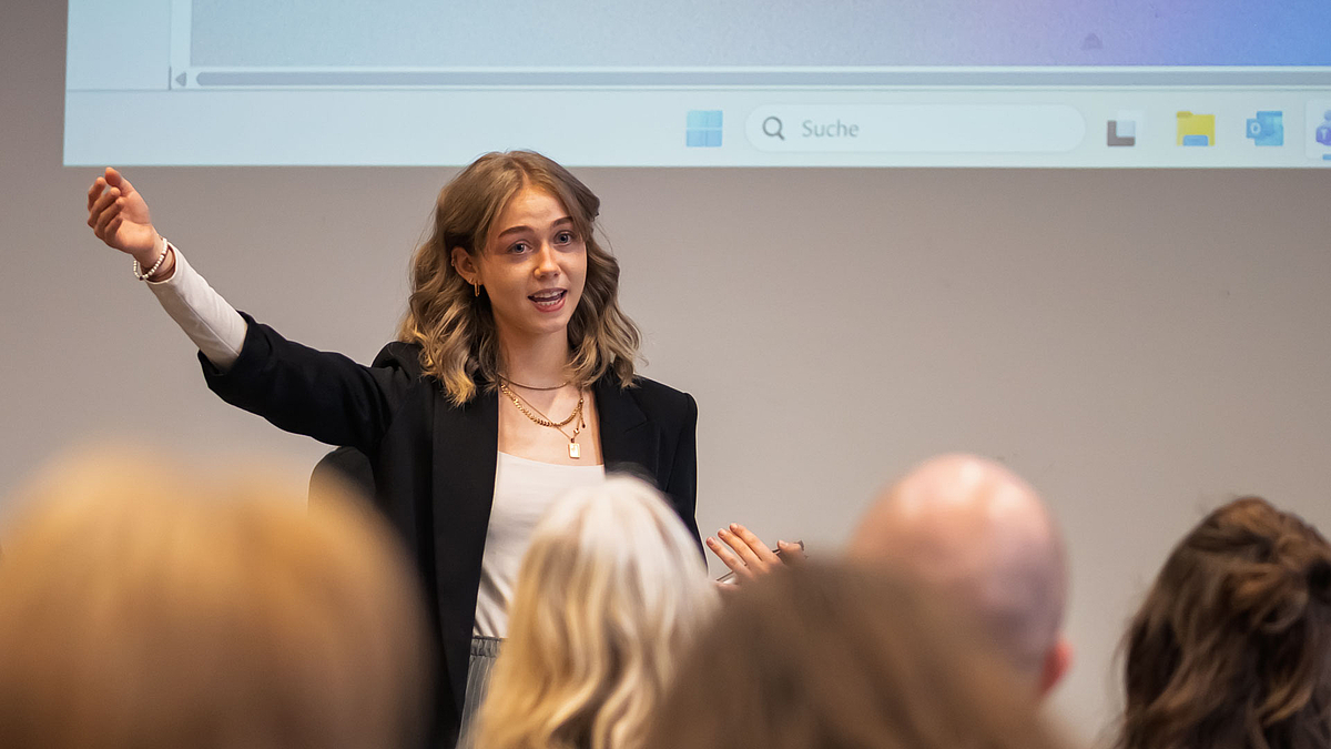 Weibliche Person vor Publikum agierend