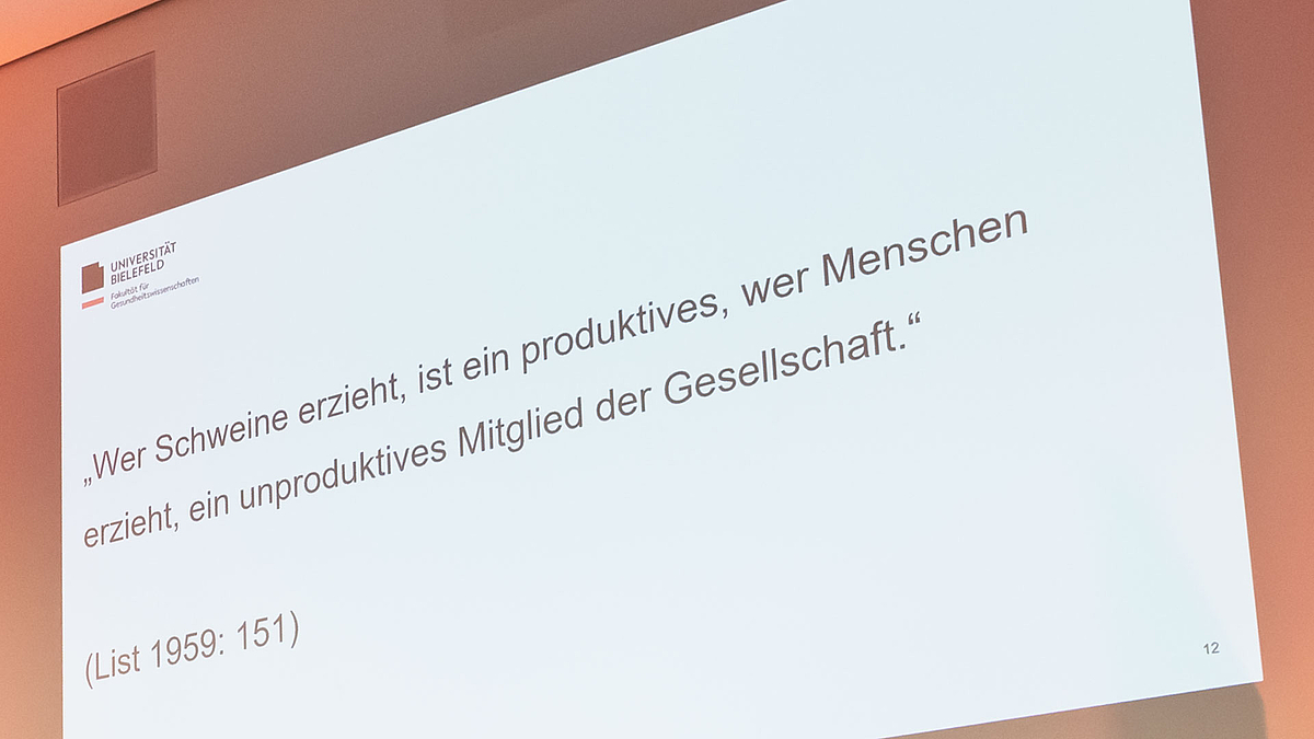 Eine Folie projiziert an die Hörsaalwand mit dem Zitat des Nationalökonomen Friedrich List aus dem Jahre 1841: „Wer Schweine erzieht, ist ein produktives, wer Menschen erzieht, ein unproduktives Mitglied der Gesellschaft.“