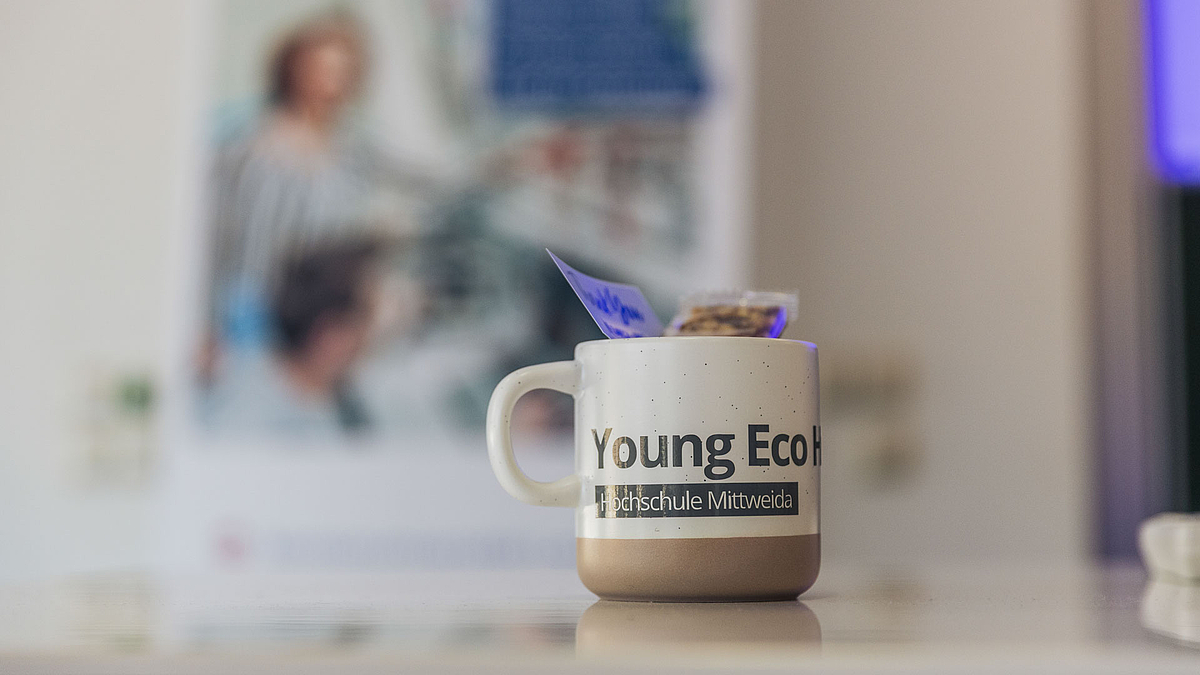 Eine Tasse mit "Young Eco Heroes"-Schriftzug
