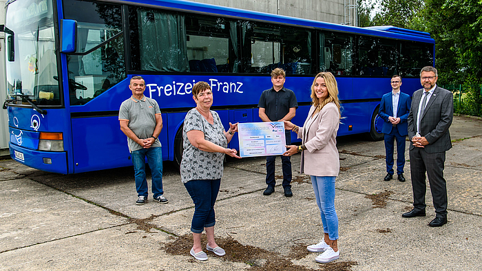 Rollt bald wieder mit Unterstützung aus Wirtschaft und Wissenschaft in Mittweida: der „Freizeit-Franz“. Dietmar Ulbricht und Petra Frevert freuen sich – mit ihnen Prof. André Streek, Madlen Rabe, Prof. Frank Schumann, Prof. Detlev Müller (v.l.) Das Foto zeigt vier männliche und zwei weibliche erwachsene Personen untschiedlichen Alters vor einem blauen Bus mit der Aufschrift "Freizeit Franz". In der Bildmitte vorne halten die zwei Frauen einen großen symbolischen Spendenscheck.