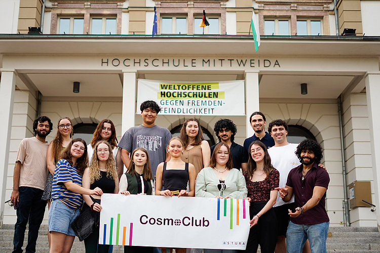 Cosmopolitan Team standing in front of House 1 of the University