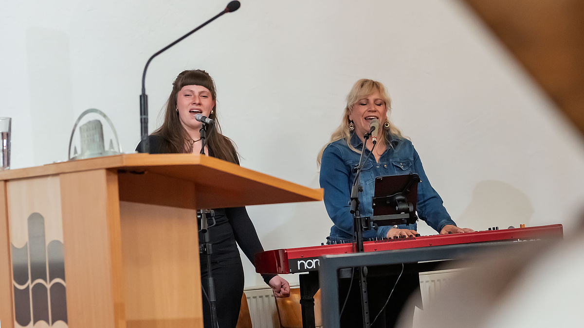 Zwei Musikerinnen singen, einen von ihnen spielt Keyboard
