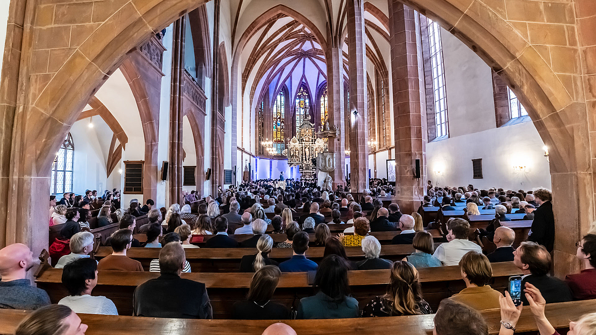Blick von hinten in die gefüllten Bankreihen des Kirschenschiffs