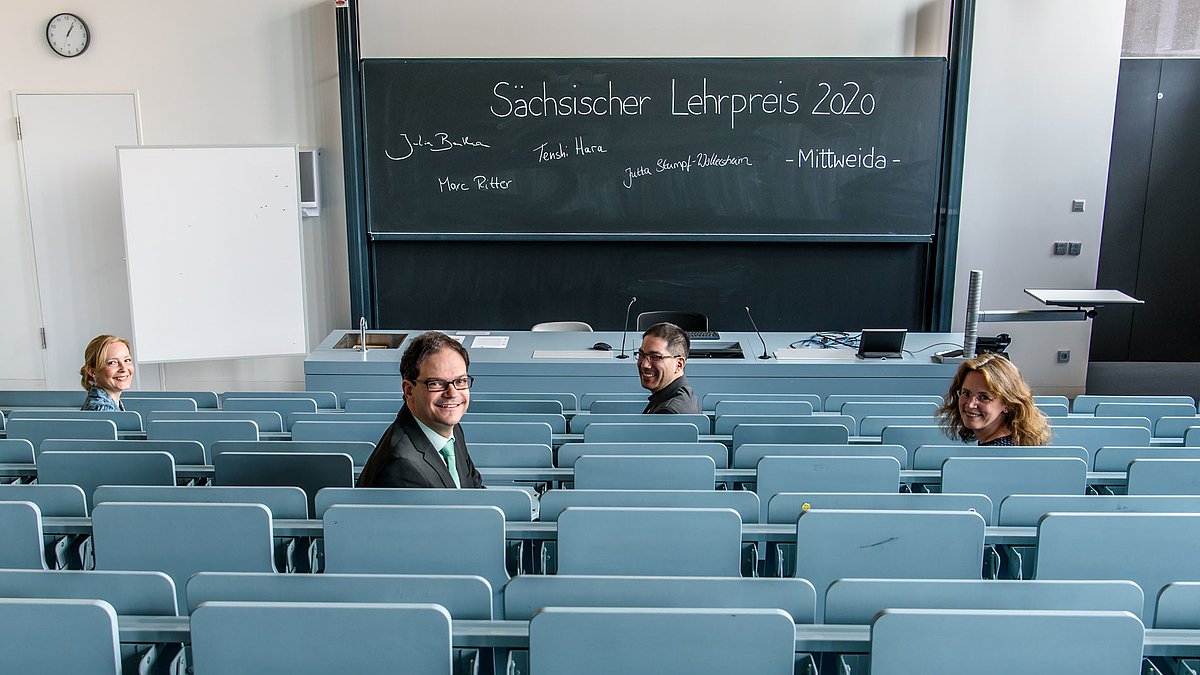 An der Hochschule Mittweida mit dem wichtigsten Lehrpreis im Freistaat Sachsen ausgezeichnet: Julia Bartha von der Hochschule für Musik und Theater „Felix Mendelssohn Bartholdy“ Leipzig, Professor Dr. Marc Ritter von der Hochschule Mittweida, Profes Auf dem Foto sind alle Preisträger zu sehen. Sie sitzen verteilt in eim großen Hörsaal und wenden dem Betrachter den Blick zu. Auf der Tafel im Hintergrund sind mit Kreide geschrieben die Worte "Sächsischer Lehrpreis 2020 Mittweida" sowie die Namen der Preisträger in je eigener Handschrift.