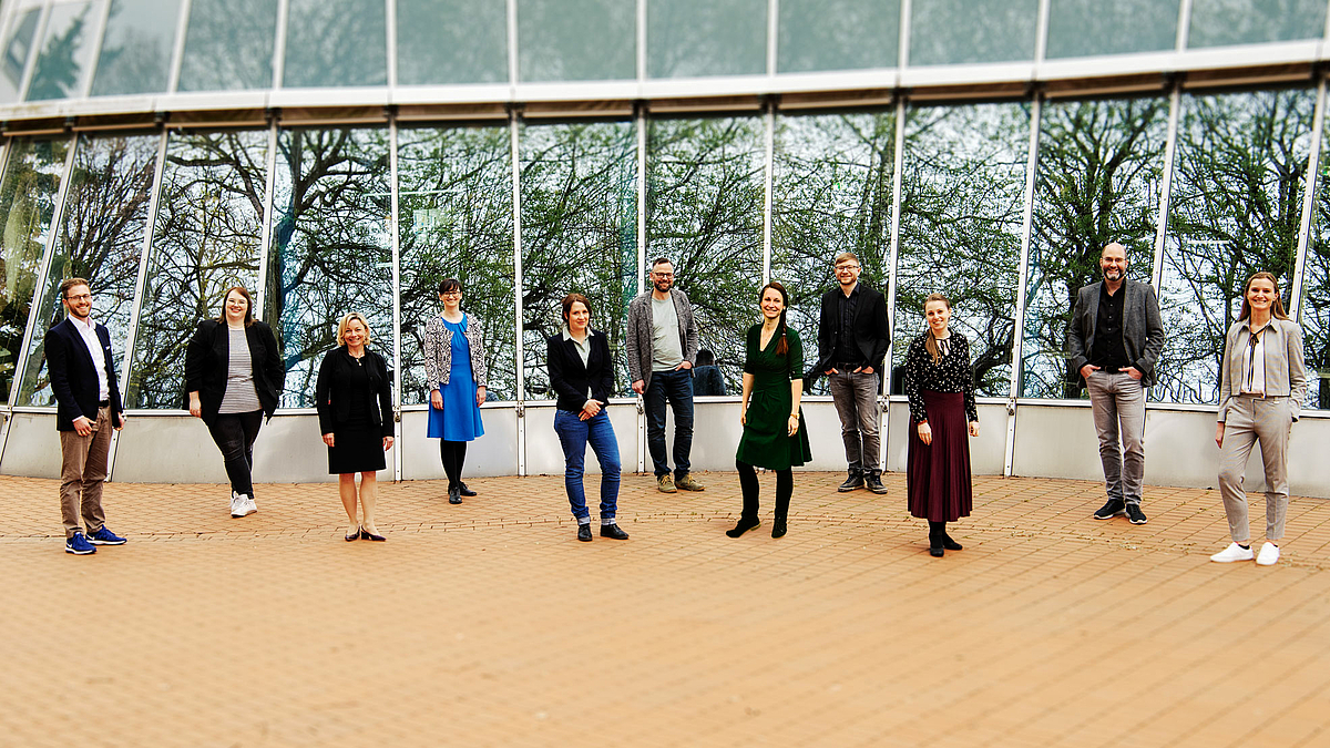 Das Foto zeigt 11 Personen vor der Glasfassade des Gerhard-Neumann-Baus stehend.