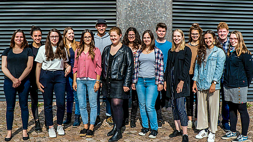 Auf dem Foto sind 15 junge Frauen udn Männer zu sehen, die sich zu einem Gruppenbild aufgestellt haben.