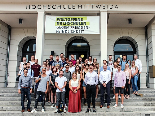 Stehen auf der Stufen des ehrwürdigen "Haus1" der Hochschule und planen für Siemens neue Gebäude: Mittweidaer Immobilien- und Facilities-Management-Studierende.