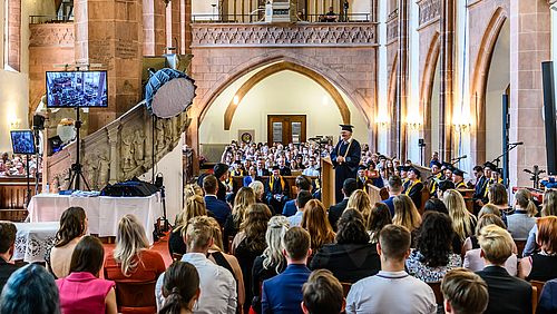 Doppelter Abschied: Rektor Ludwig Hilmer bei der letzten Feierlichen Exmatrikulation seiner Amtszeit inmitten der Festgemeinde aus Absolvent:innen, Angehörigen und Professor:innen.