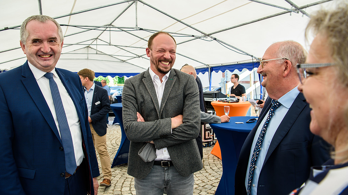 Gute Stimmung, aber: „Den Zeitplan für Innovationen gibt die Politik mit vor“, mahnte Rektor Ludwig Hilmer (2.v.r.) Staatsminister Thomas Schmidt, den Ostbeauftragten Marco Wanderwitz und Bundestagsbageordnete Veronika Bellmann. Das Foto zeigt vier Personen bester Laune in einem Pavillon mit Stehtischen: Thomas Schmidt, sächsischer Staatminister für Regionalentwicklung, Marco Wanderwitz, Beauftragter der Bundesregierung für die neuen Bundesländer, Ludwig Hilmer, Rektor der Hochschule Mittweida, und die Bundestagsabgeordnete Veronika Bellmann (v.l.n.r.).