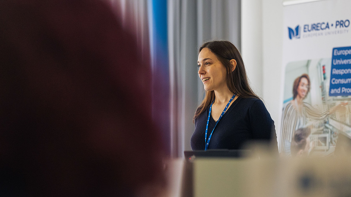 Eine ewachsene weibliche Person vor einem EURECA-PRO-Rollup