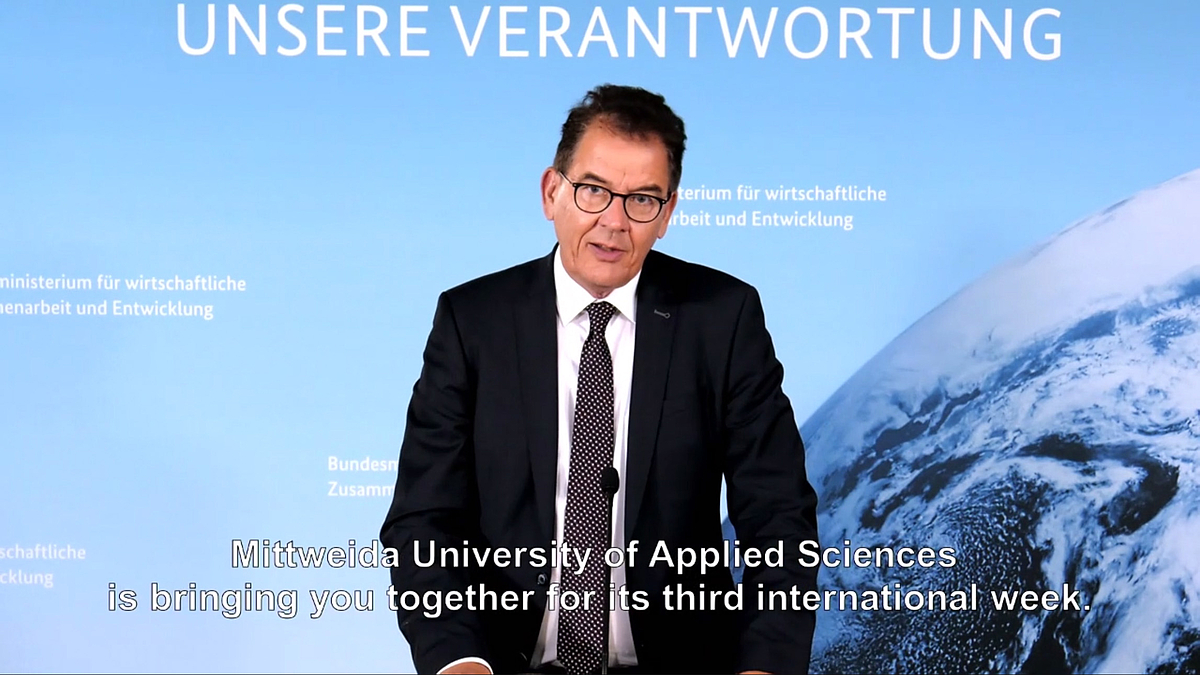 Beschreibung: Screenshot der Videobotschaft von Dr. Gerd Müller, Bundesminister für wirtschaftliche Zusammenarbeit und Entwicklung. Im Untertitel ist zu lesen: „Mittweida University is bringing you together for its third international week“.