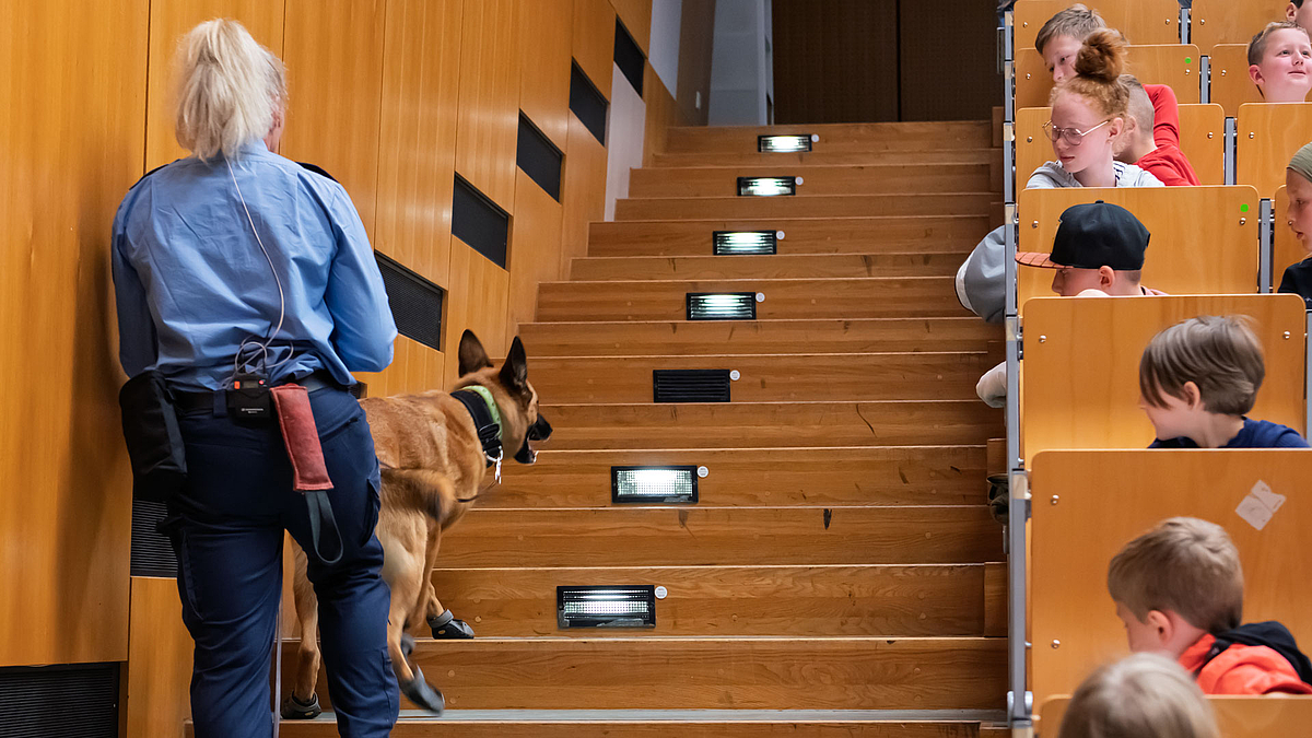 Der Hund mit seiner Hundeführerin auf Spurensuche im Hörsaal.