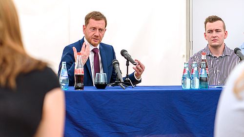 Ministerpräsident Michael Kretschmer spricht zu den Studierenden der Hochschule Mittweida. Rechts neben ihm sitzt Gordon Guido Oswald, Geschäftsführer des Studentenrats Mittweida.