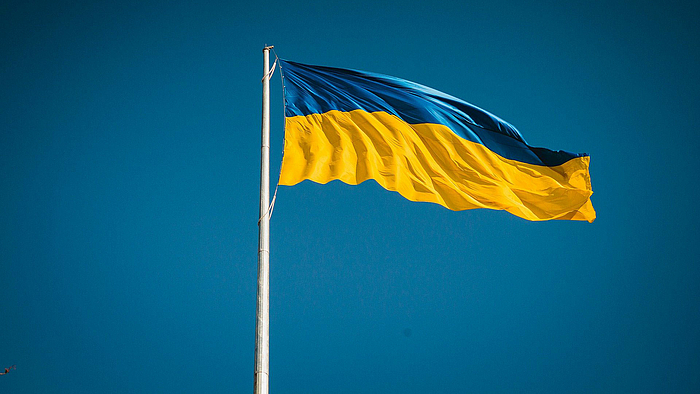 Die blau-goldene Flagge der Ukraine weht an einem Mast im Wind.