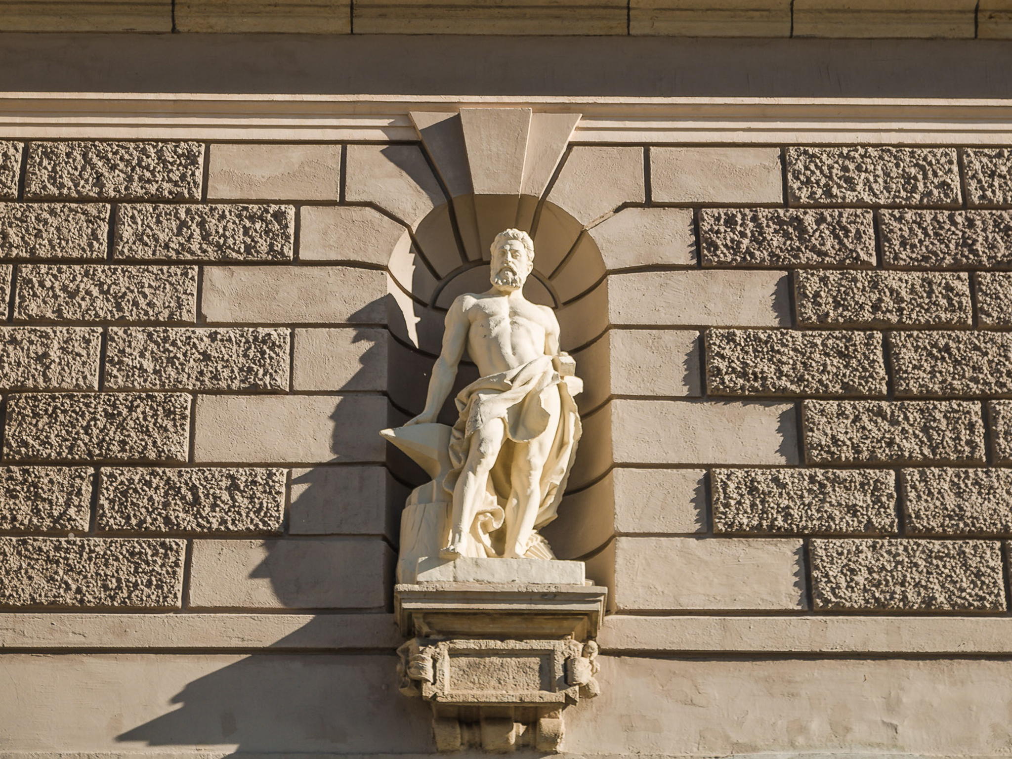 Eine von zwei Figuren an der Fassade zeigt Hephaistos, den griechischen Gott des Feuers und der Metallkünste; die andere ist Elektra.