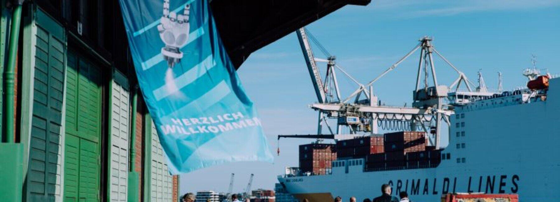 View of a port building with people and a container ship