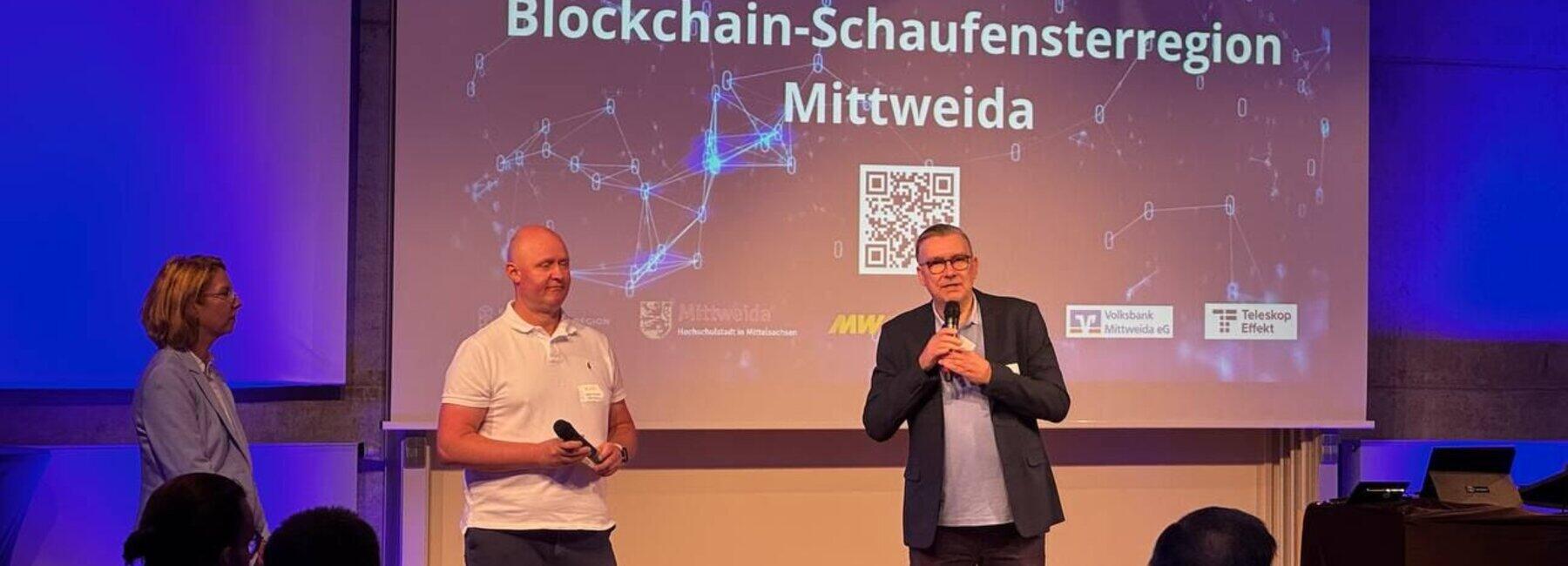 Drei Personen stehen vor einer Projektionswand