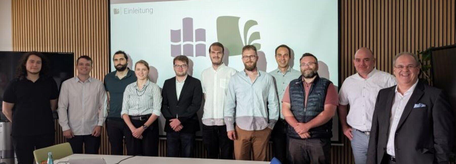 Gruppenbild vor einer Präsentationswand