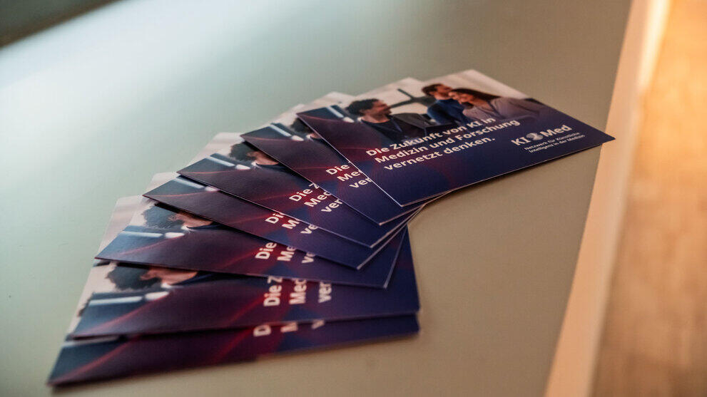Zu einem Fächer gelegte Flyer des Projekts „KI Med“.