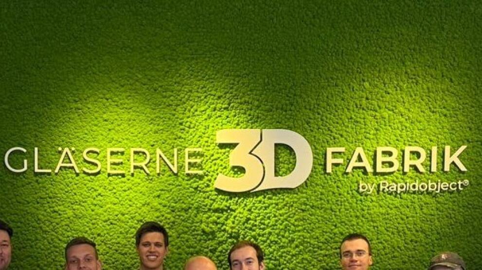 Gruppenbild vor einer grünen Rückwand mit einem Schriftzug