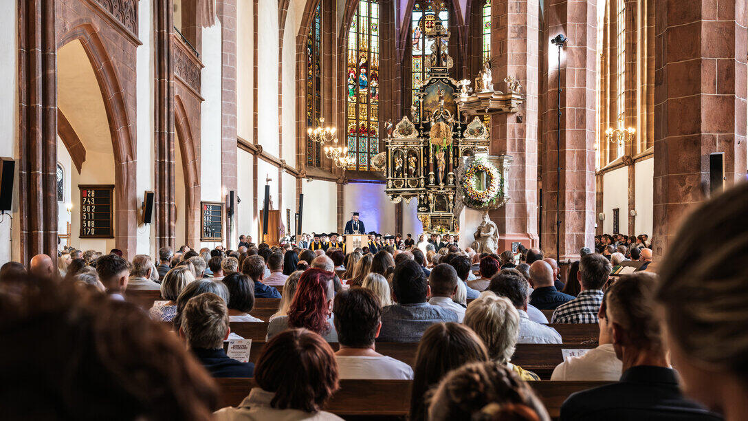 Blick vom hinteren des KIrchenschiffs über die Köpfe des Publikums hinweg nach vorn Richtung Altarraum.
