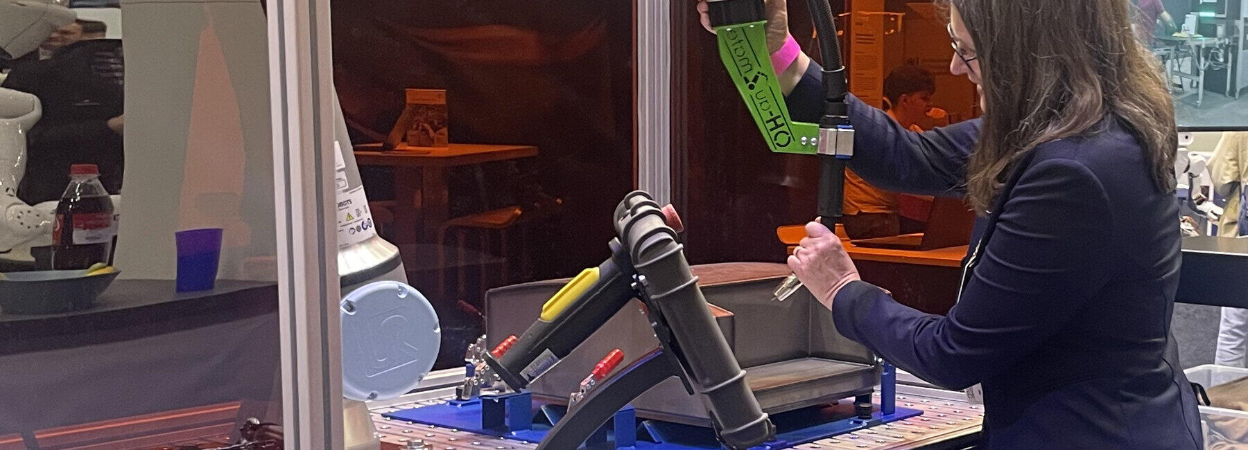 Zwei Personen stehen an einem Schweißroboter