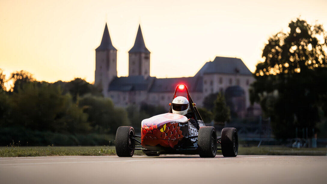 Rennauto vor der Kulisse eines Schlosses im Hintergrund.