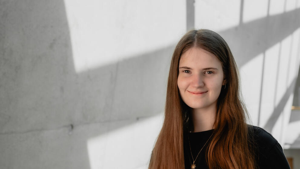Portrait einer weiblichen Person vor einer Betonwand