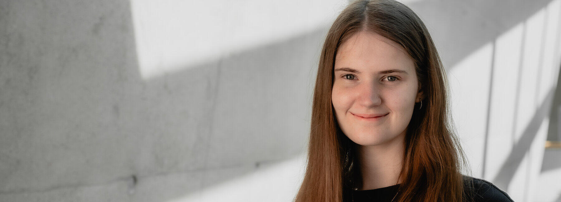 Portrait einer weiblichen Person vor einer Betonwand