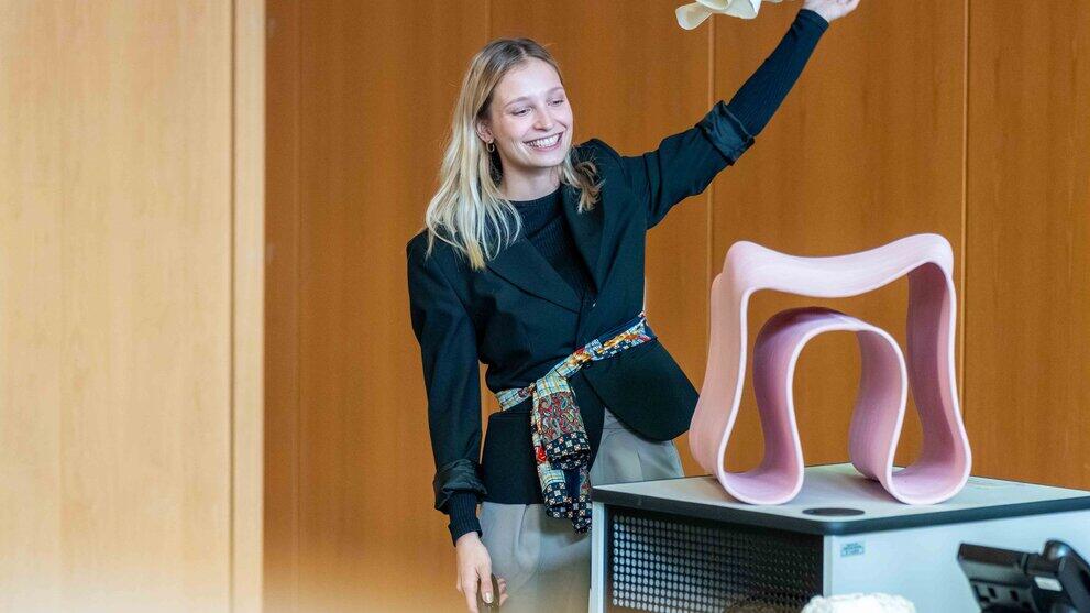 weibliche Person enthüllt 3D-gedruckten Designerstuhl