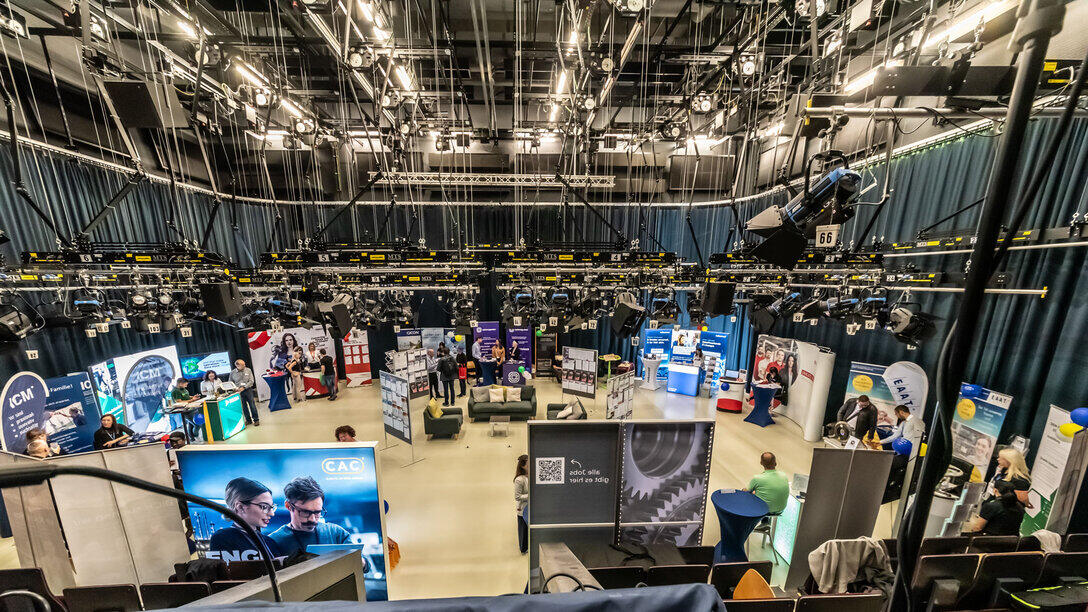 Blick in ein Fernsehstudio mit Firmenständen