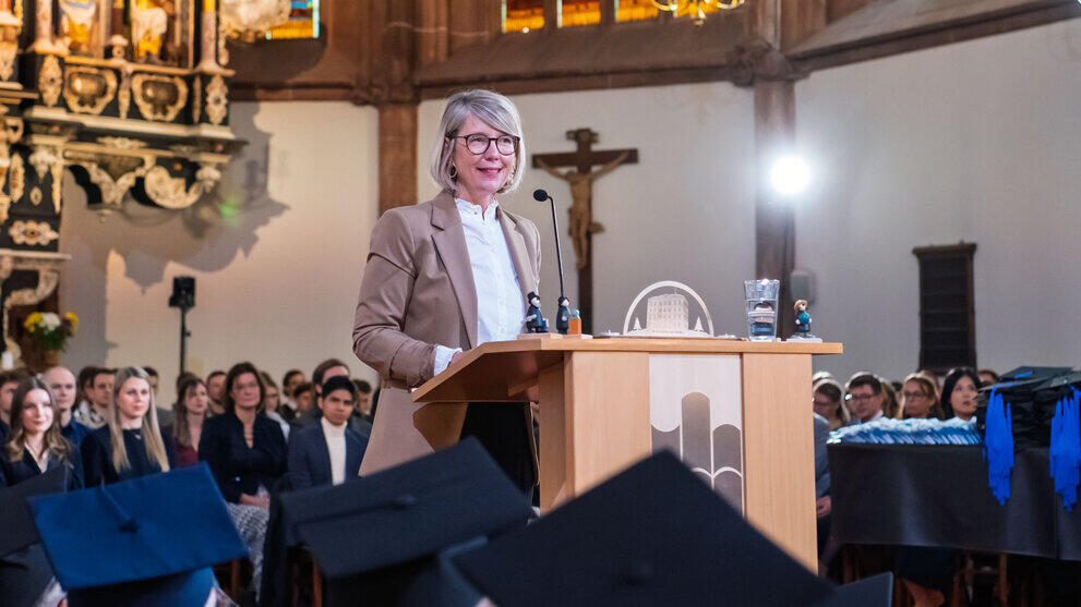 The same person as in the previous picture at the lectern, with graduates behind them in the chancel.
