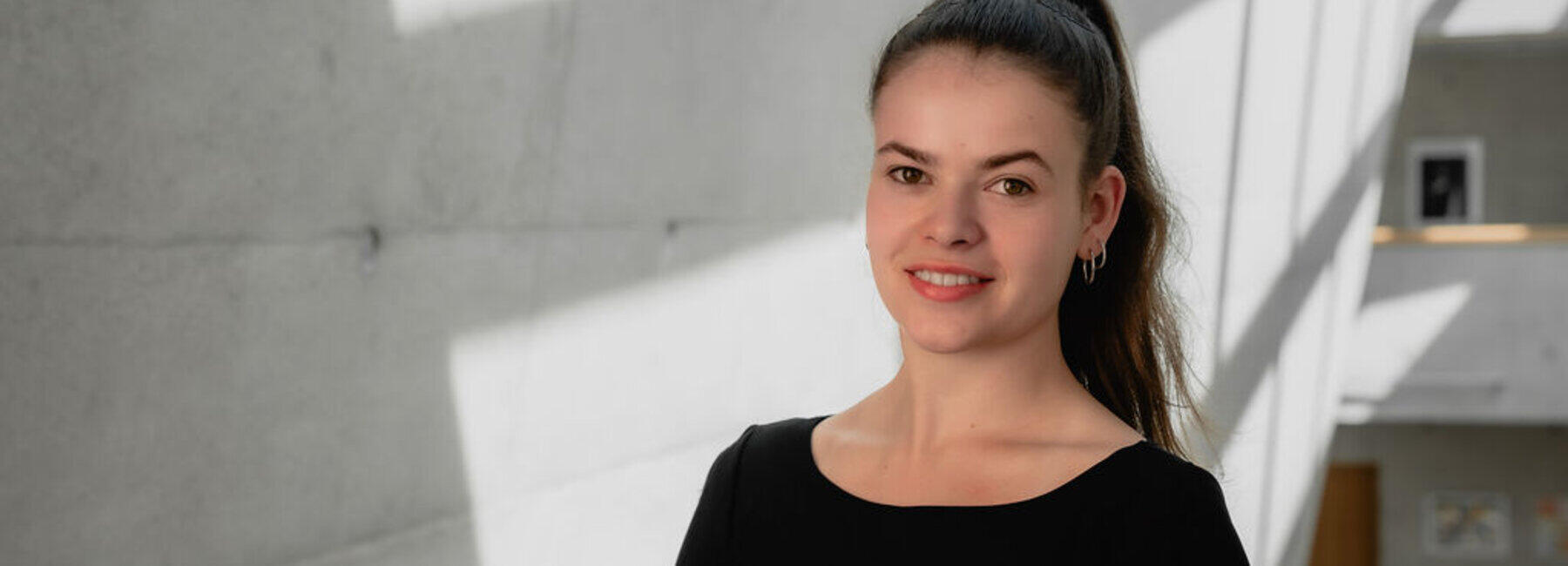 Portrait einer weiblichen Person vor einer Betonwand