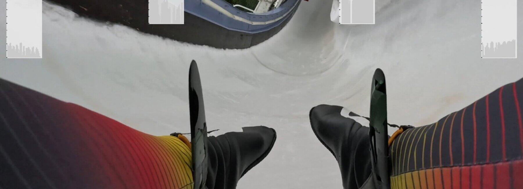 Blick auf die Füße eines Bobpiloten mit der Eisbahn und Fenstern für Messkurven
