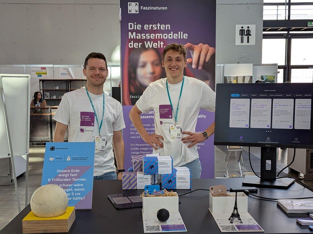 Two men are standing at an exhibition stand