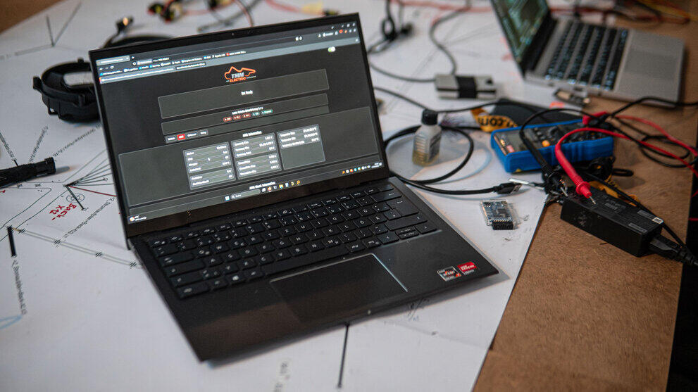 Aufgeklappter Laptop. Auf dem Display ist die Benutzeroberfläche des Diagnosers mit dem Logo von TMM zu sehen.
