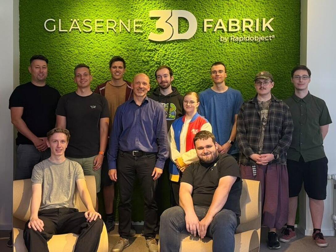 Gruppenbild vor Firmenlogo