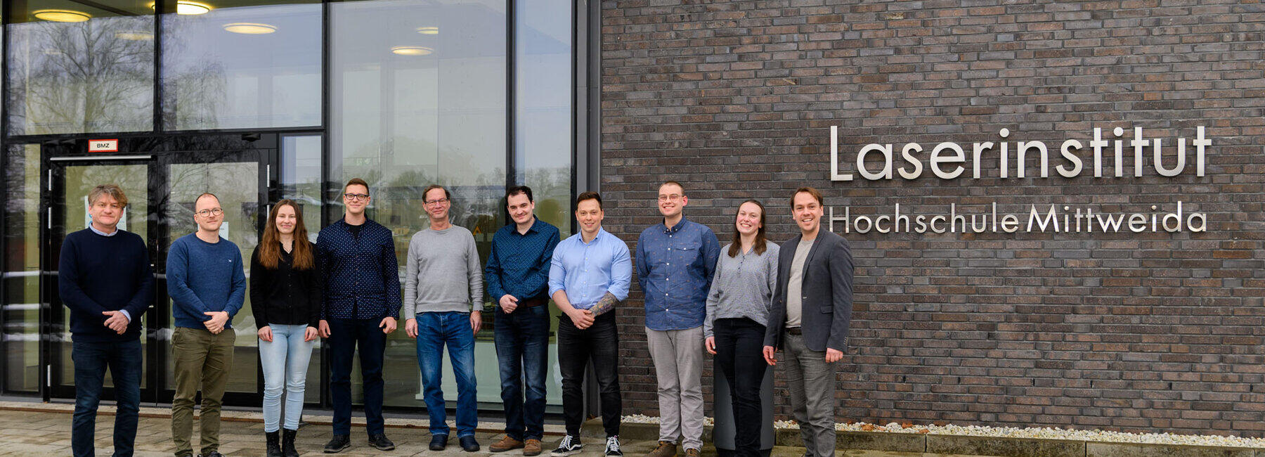 Zehn Personen stehen vor dem Eingang des Laserinstitut Hochschule Mittweida