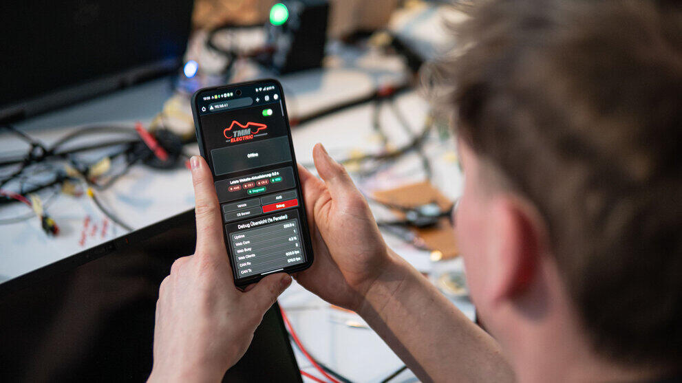 Die Hände einer Person halten ein Smartphone, auf dem die mobile Oberfläche des Diagnosers zu sehen ist.