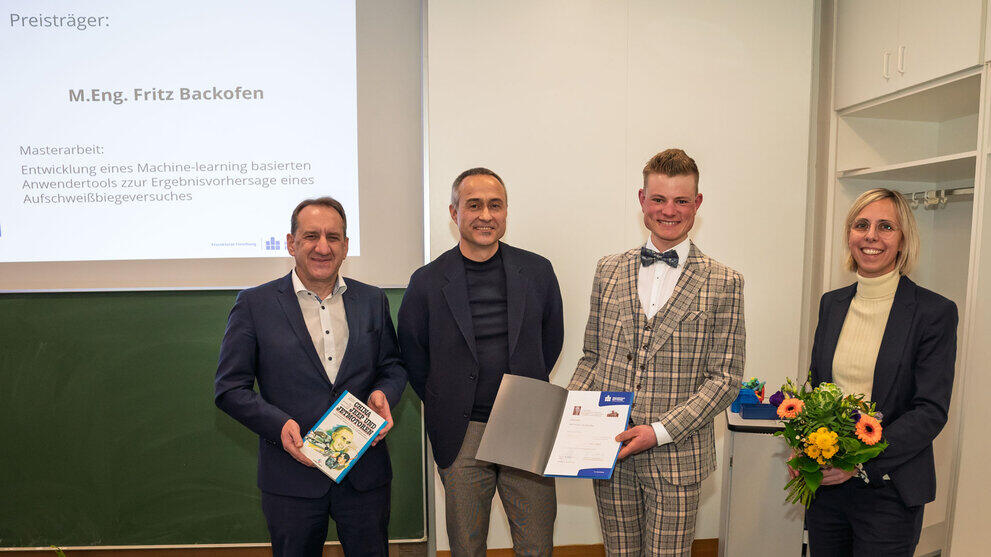 4 Personen stehen im Raum vor der Präsentationstafel