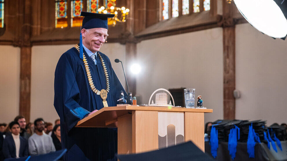 The same person as in the previous picture, smiling at the lectern