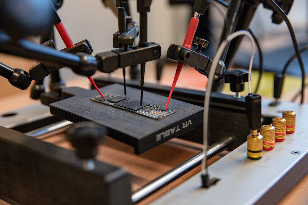 Eine feinmechanische Prüfstation prüft eine defekte SSD-Platine.