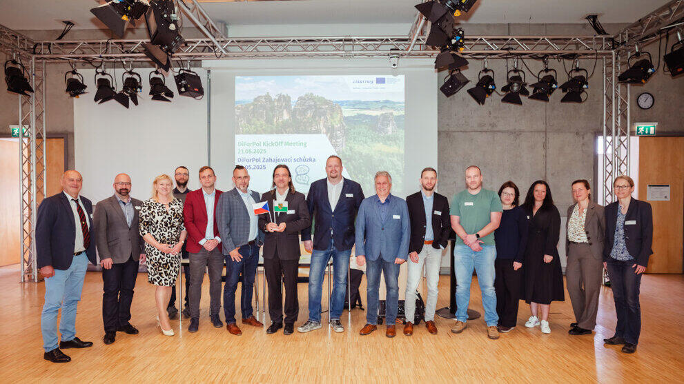 Gruppenbild in einem Studio vor einer Präsentationswand
