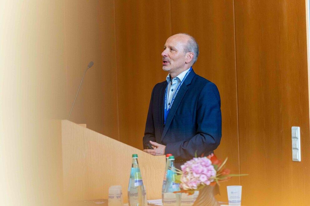 Eine männliche Person steht hinter einem Rednerpult