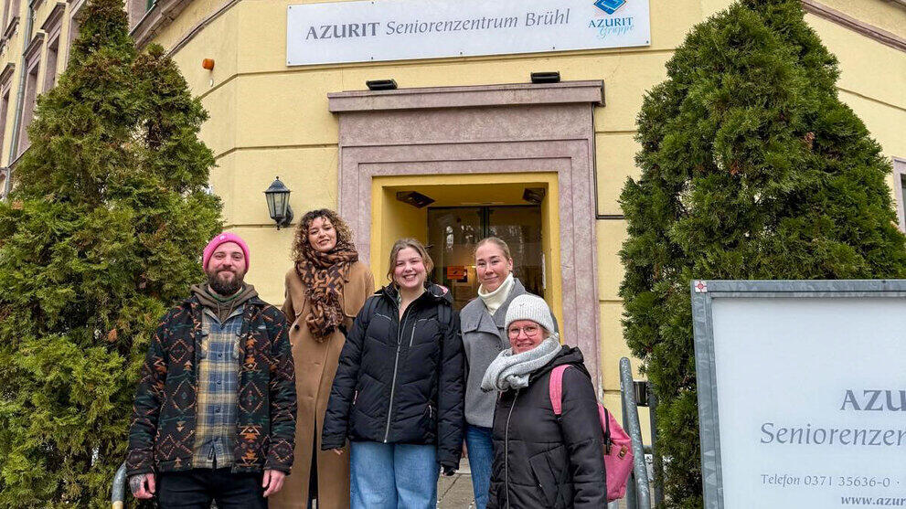 Fünf Personen vor einem Hauseingang. Über die Tür ein Schild mit "Azurit Seniorenzentrum Brühl"