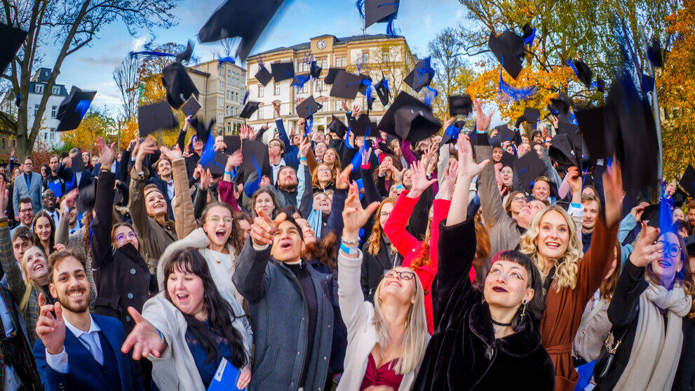 The resulting photo showing jubilant graduates and flying hats.